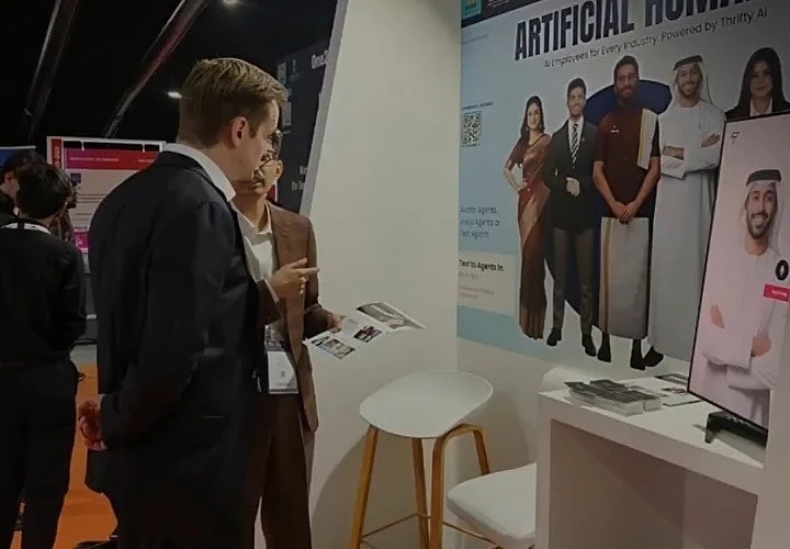 Visitors at the Thrifty AI booth, with Khalid on the kiosk