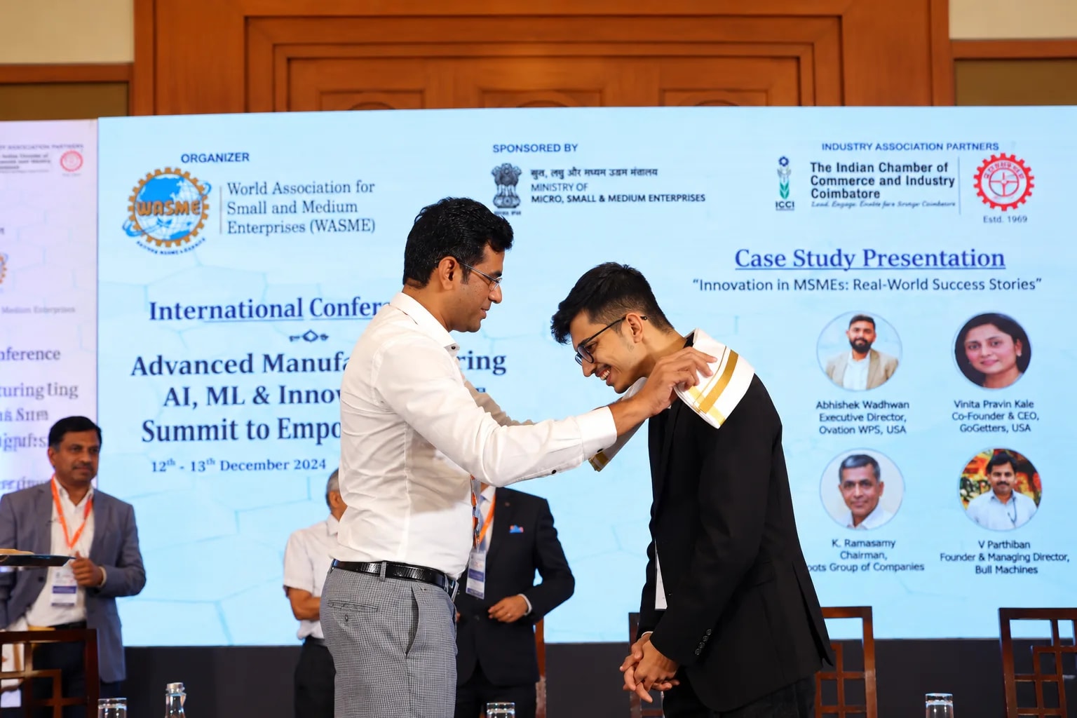 Harsh Jha being presented with a scarf at the conference