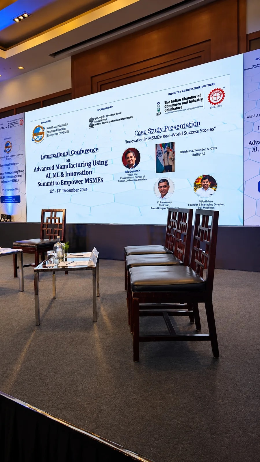 The conference stage, with Thrifty AI's case study presentation on screen