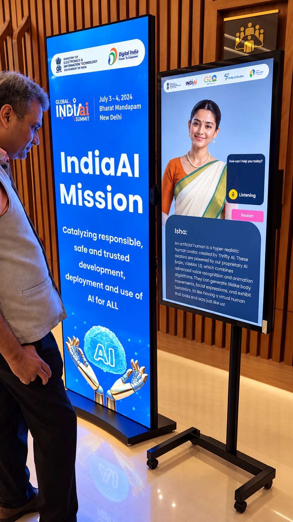A visitor at the Global IndiaAI Summit talking to a Thrifty AI kiosk with an AI host in a saree